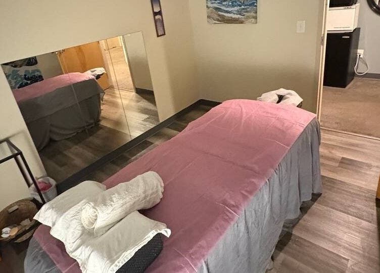 Cozy massage room at Tropical Touch Columbus LLC in Columbus, Ohio, US, featuring a welcoming pink-sheeted bed.