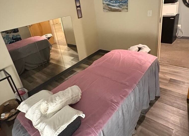 Cozy massage room at Tropical Touch Columbus LLC in Columbus, Ohio, US, featuring a welcoming pink-sheeted bed.