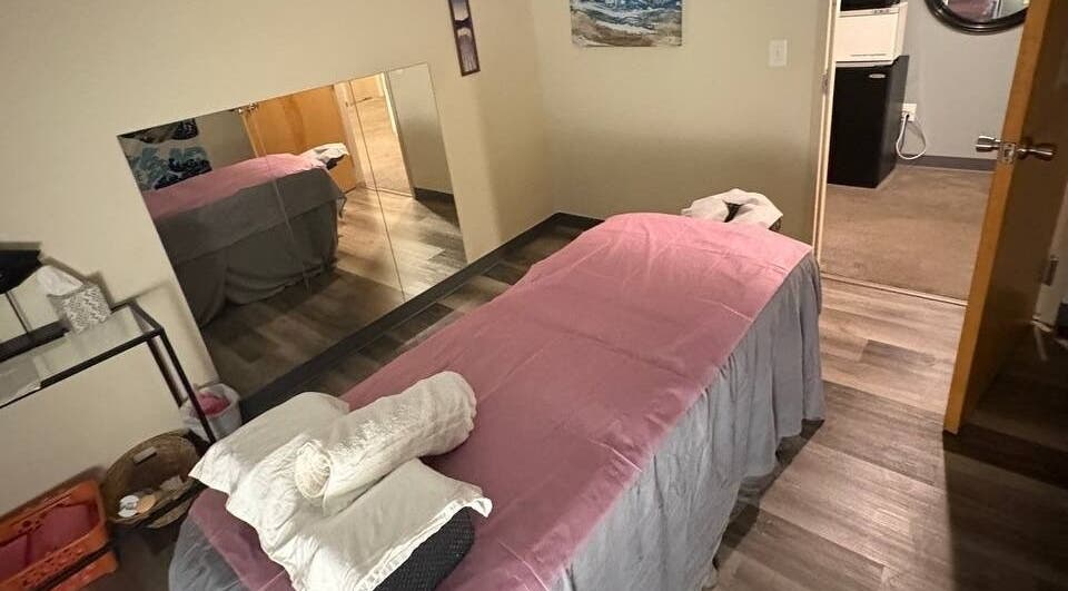 Cozy massage room at Tropical Touch Columbus LLC in Columbus, Ohio, US, featuring a welcoming pink-sheeted bed.