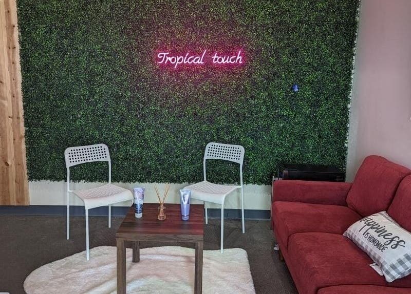 Cozy seating area at Tropical Touch Columbus LLC, Columbus, Ohio, US with a green wall and red sofa.