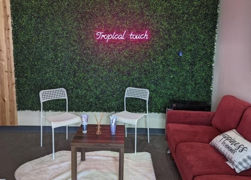Cozy seating area at Tropical Touch Columbus LLC, Columbus, Ohio, US with a green wall and red sofa.