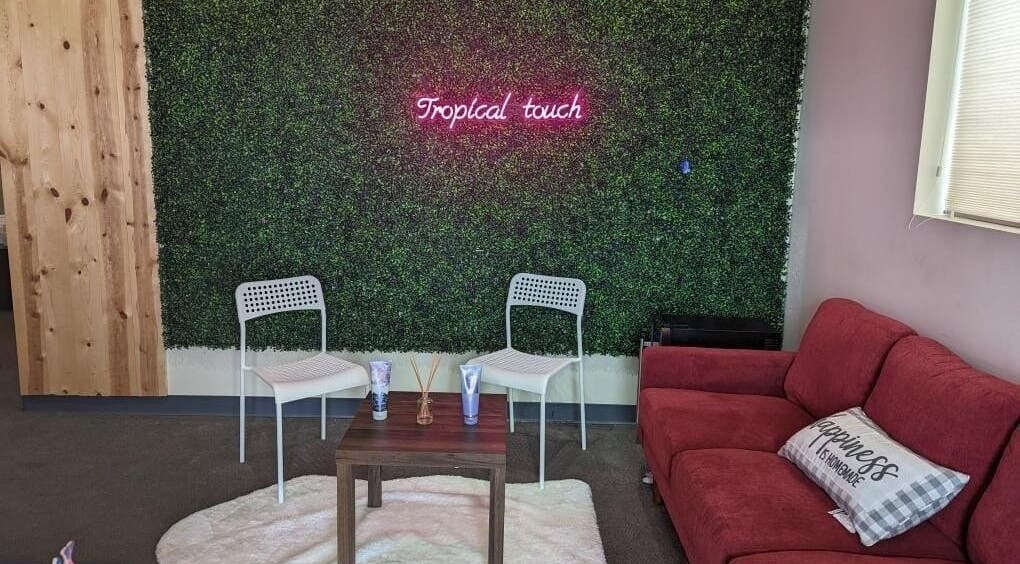 Cozy seating area at Tropical Touch Columbus LLC, Columbus, Ohio, US with a green wall and red sofa.