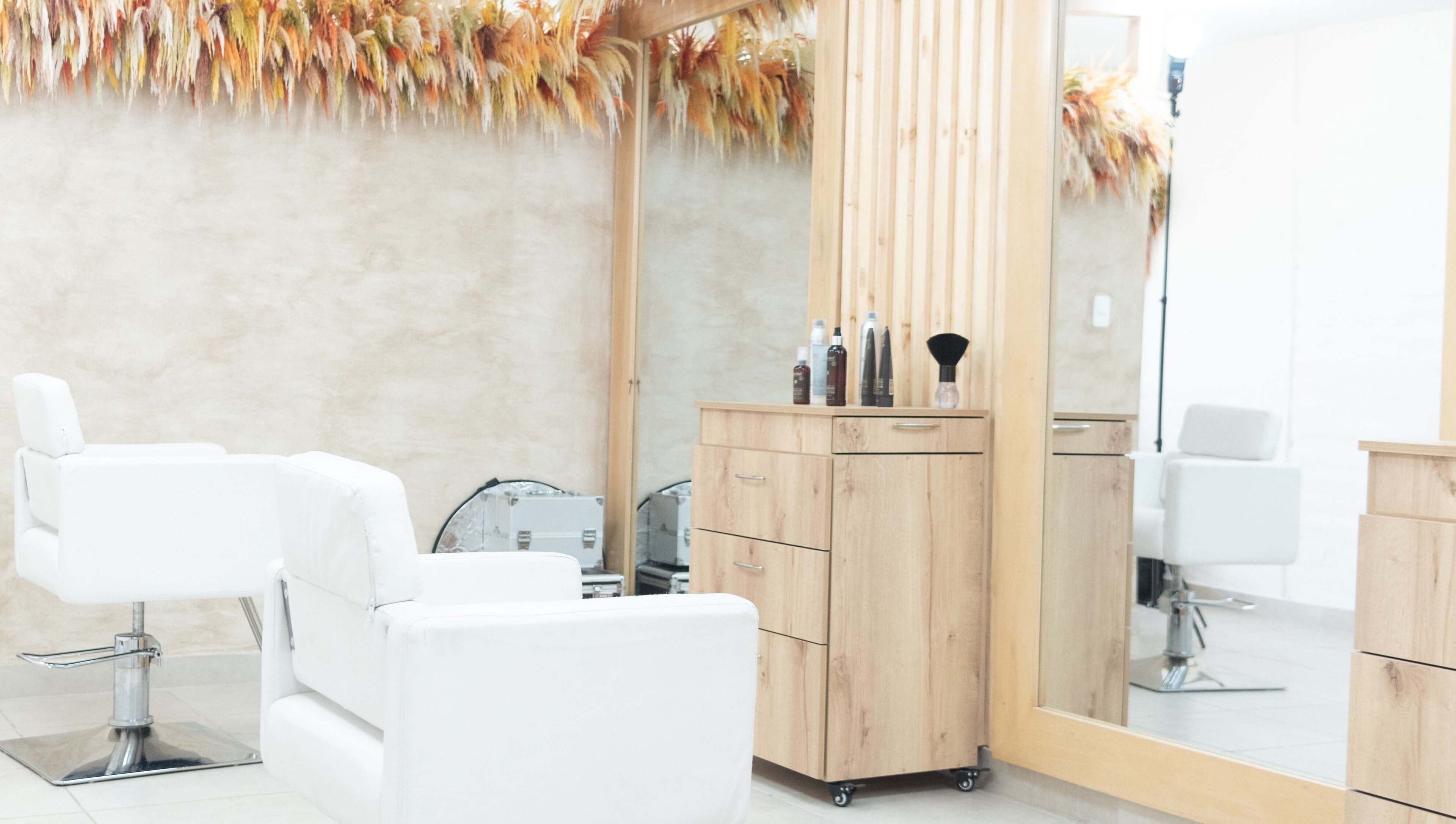 Interior moderno de OKO - Belleza con Propósito en Quito, Ecuador, con sillas y espejo estilístico.