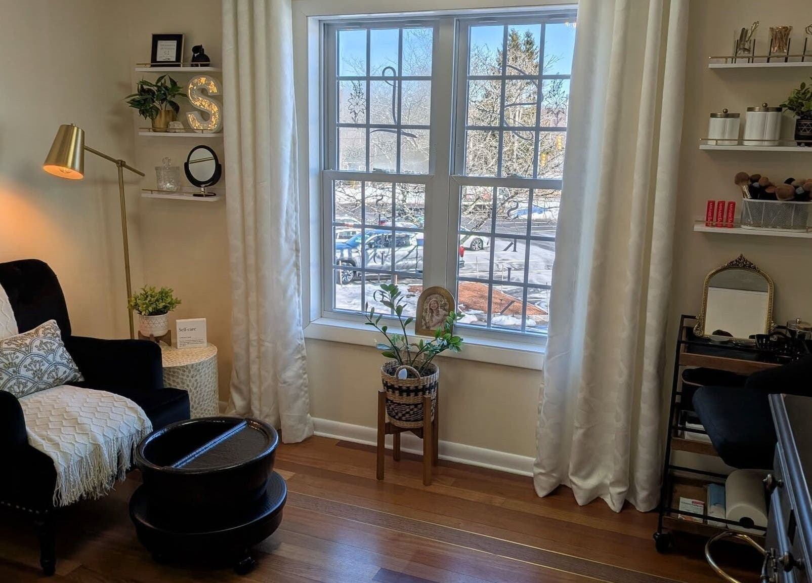 Serene treatment room at S.L. Skin Studio in Hampstead, New Hampshire, US with cozy seating and natural light.