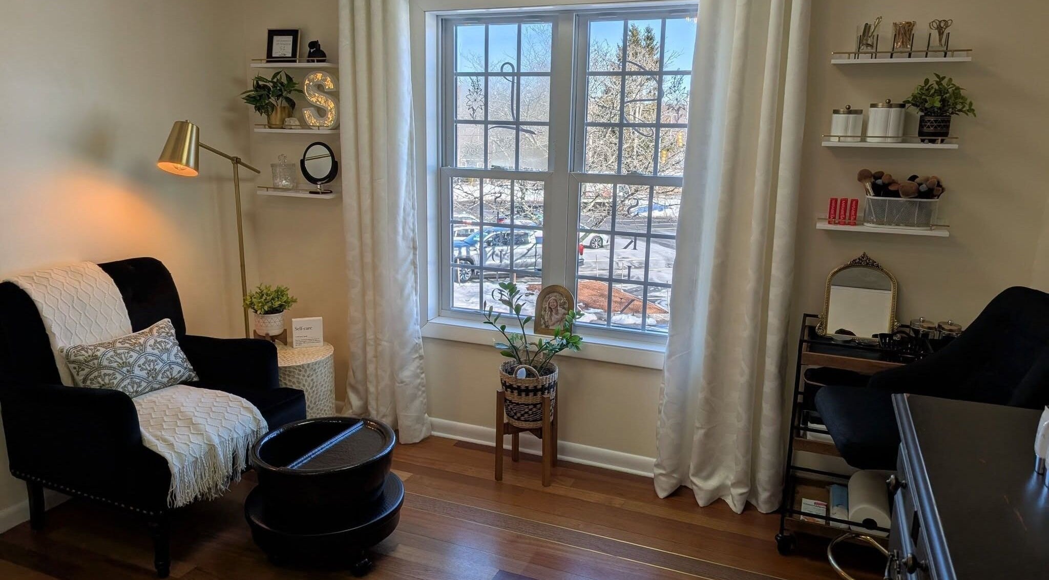 Serene treatment room at S.L. Skin Studio in Hampstead, New Hampshire, US with cozy seating and natural light.