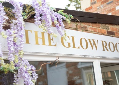 The Glow Room Brackley sign adorned with purple flowers in Brackley, England, GB.