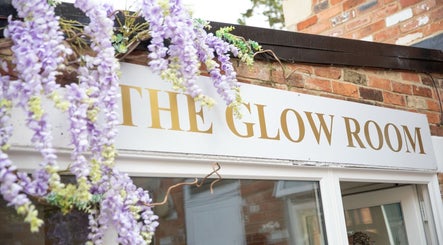 The Glow Room Brackley sign adorned with purple flowers in Brackley, England, GB.