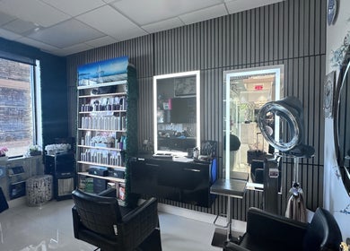 Modern interior of StavGhair salon in Parkland, Florida, US with styling chairs and illuminated mirrors.