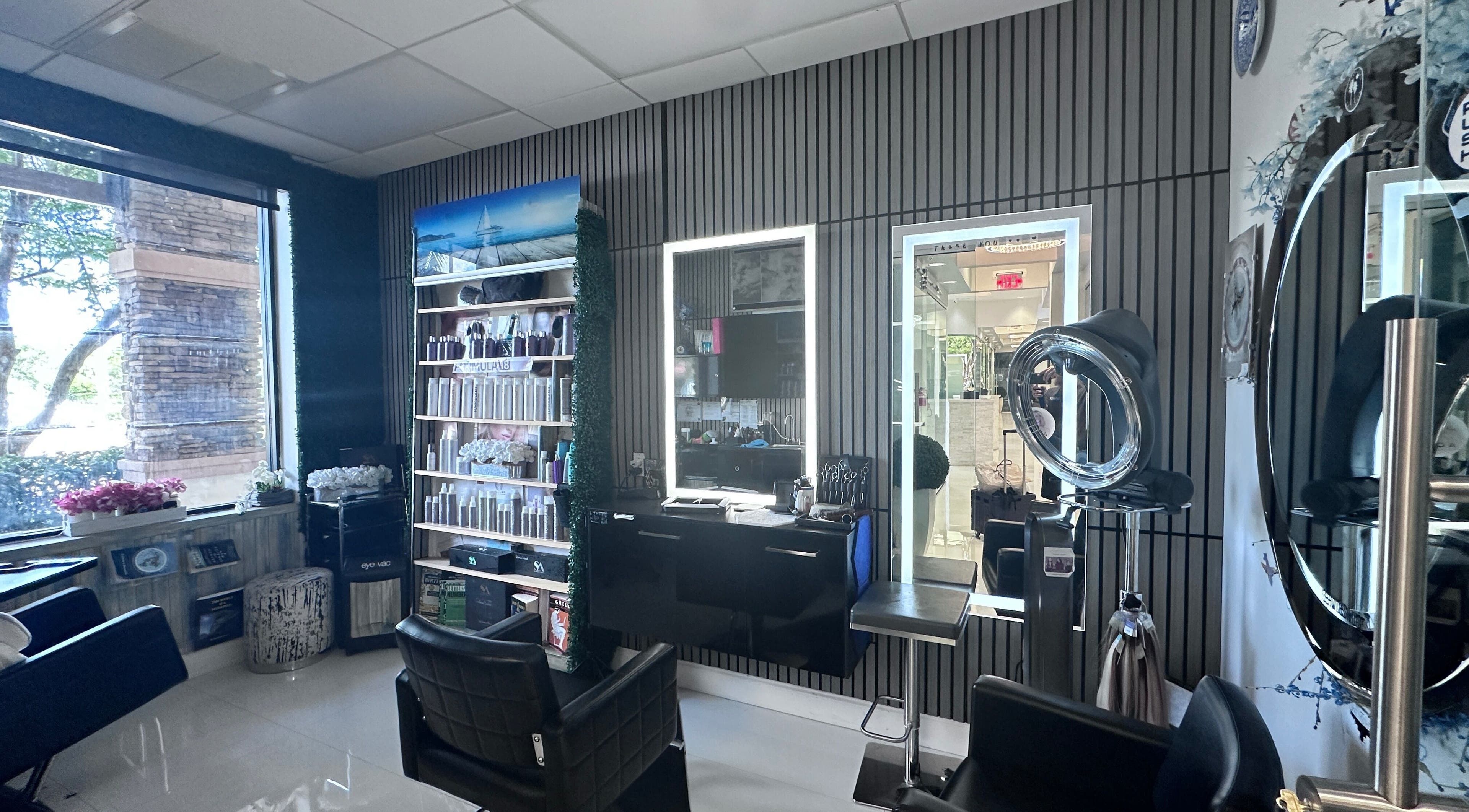 Modern interior of StavGhair salon in Parkland, Florida, US with styling chairs and illuminated mirrors.