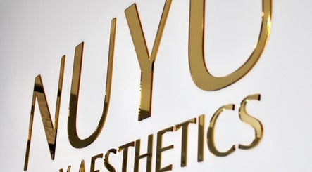 Elegant gold NUYU Body Aesthetics sign at Beckenham, England, GB, highlighting venue's stylish branding.