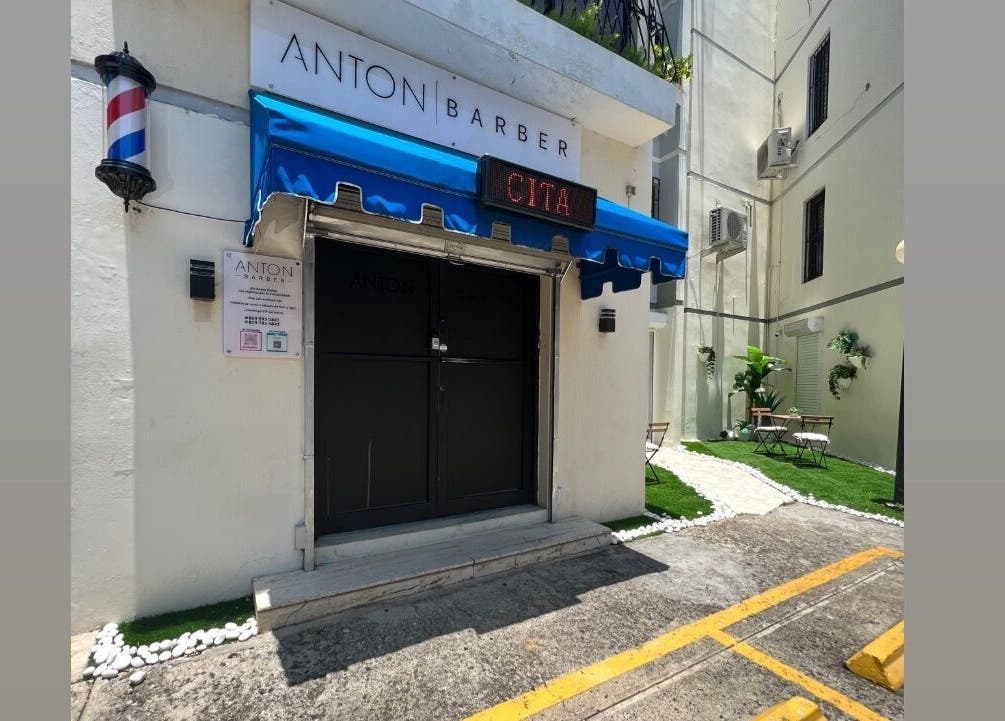 Entrada principal de Anton Barber en Santo Domingo, Distrito Nacional, DO, con toldo azul y señal de cita.