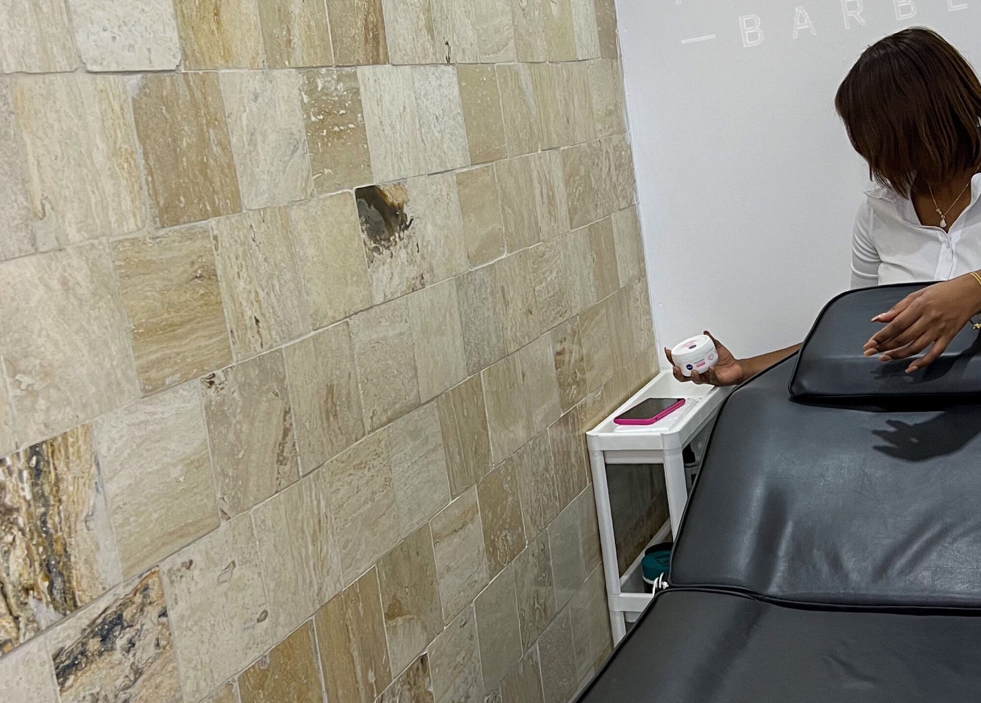 Sala de tratamiento en Anton Barber, Santo Domingo, Distrito Nacional, DO, con silla de masaje y decoración minimalista.