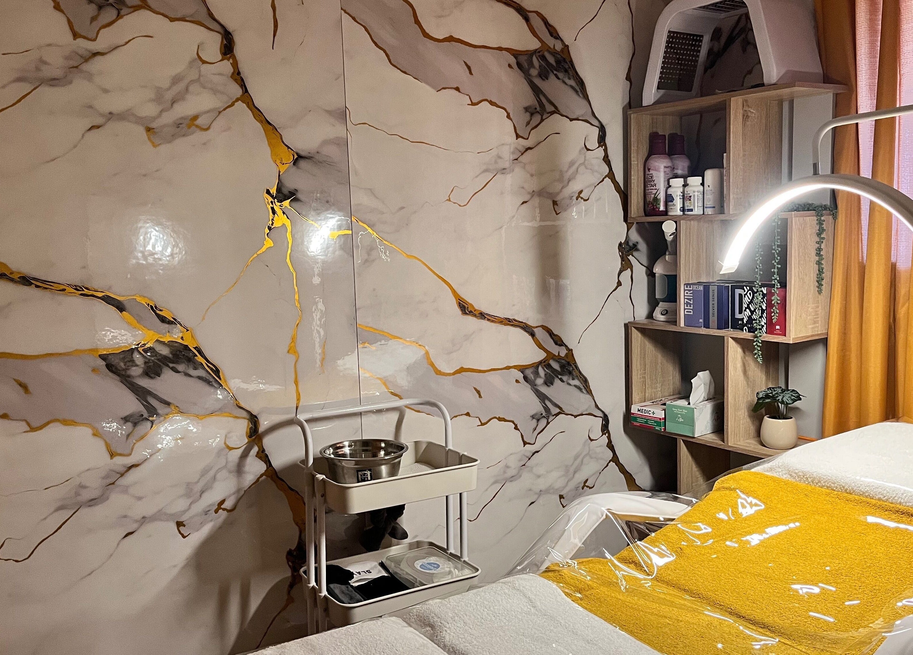 Elegant treatment room at Infinity Dermal Aesthetics, Johannesburg, Gauteng, ZA, featuring marble walls and cozy décor.