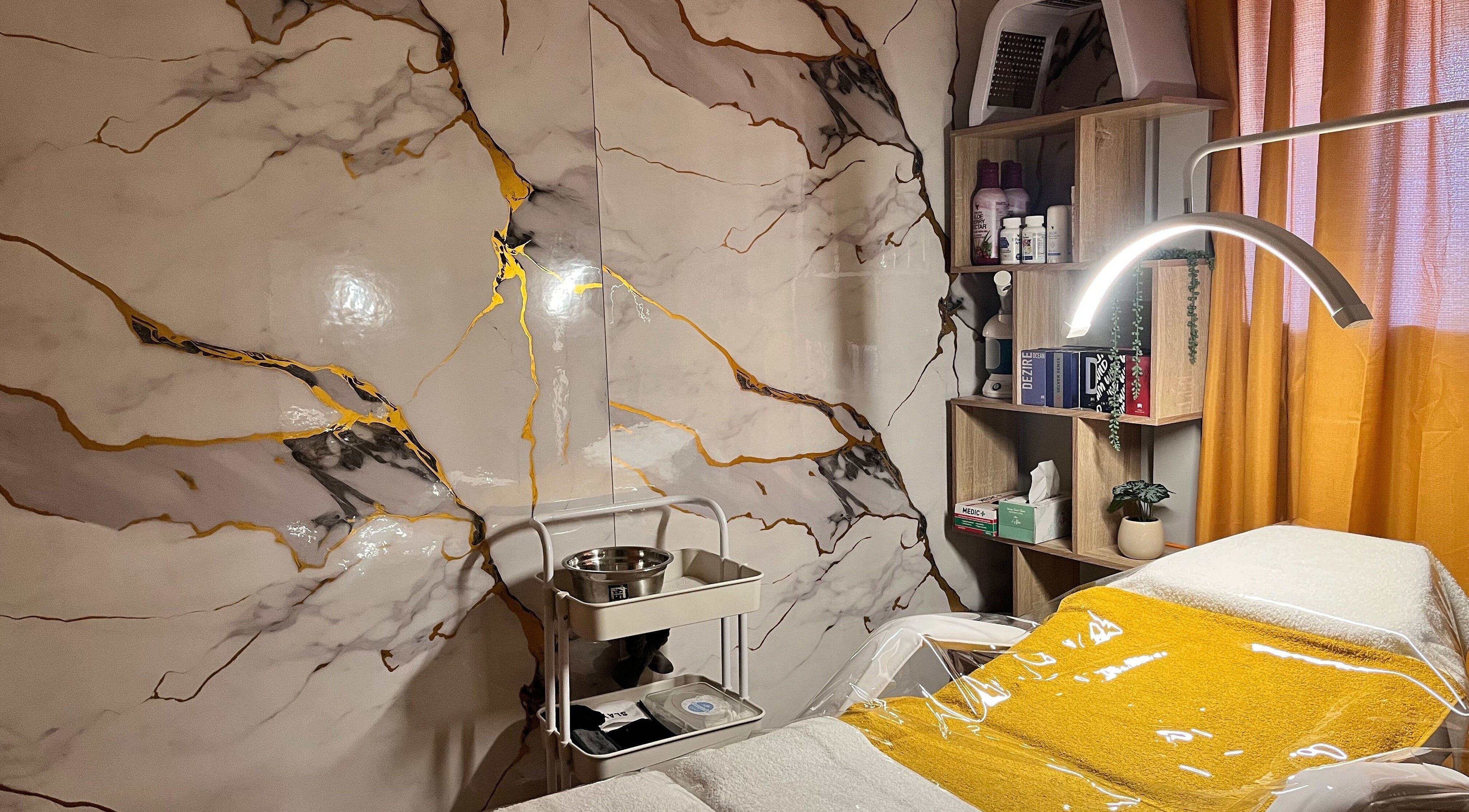 Elegant treatment room at Infinity Dermal Aesthetics, Johannesburg, Gauteng, ZA, featuring marble walls and cozy décor.