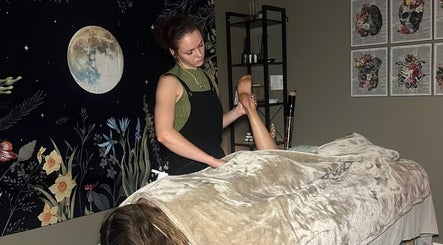 Massage therapist at Blissful Balance in Orem, Utah, US providing a relaxing treatment under a moon-themed decor.