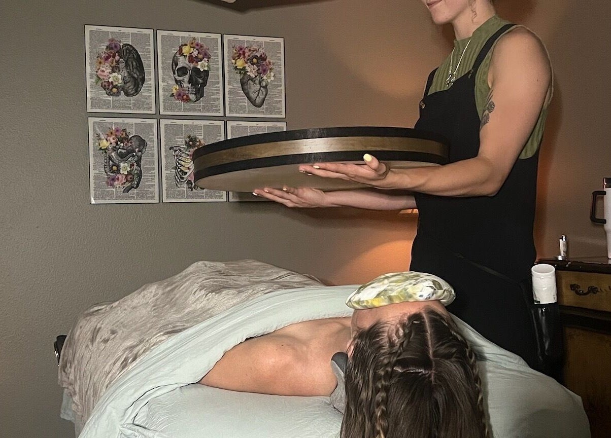 Practitioner using sound therapy at Blissful Balance, Orem, Utah, US, enhancing relaxation and wellness.