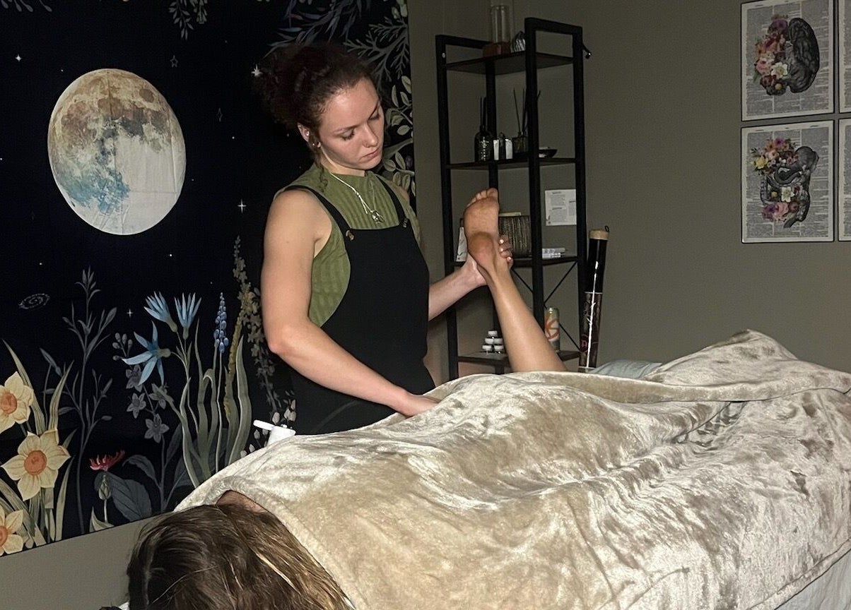 Foot massage session at Blissful Balance in Orem, Utah, US, enhancing relaxation under a calming moonlit tapestry.
