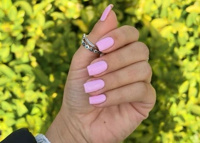 Stylish pink manicure showcased at Beauty By Ella, Tamworth, England, GB, with lush greenery background.