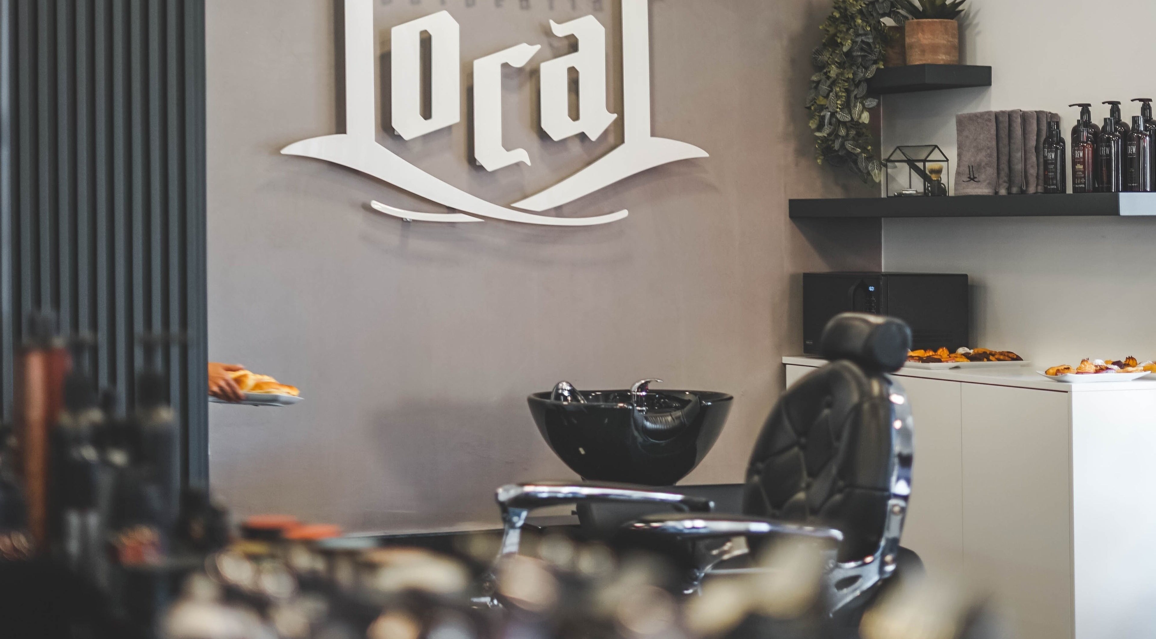 Interior moderno da Barbearia Local - Areal de Cima em Braga, Braga, PT, destacando cadeira e lavatório.