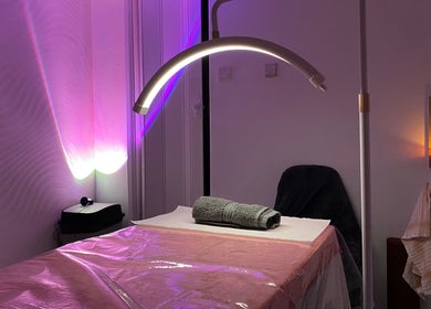 Relaxing treatment room at Embracing Beauty, Iż-żejtun, MT, with ambient lighting and plush massage table.