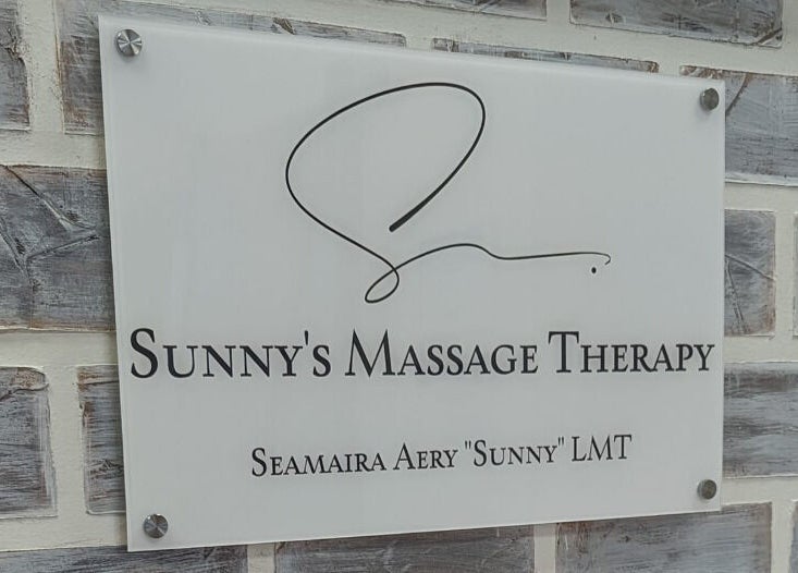 Sign for Sunny's Massage Therapy in Union City, Tennessee, US, mounted on a textured brick wall.