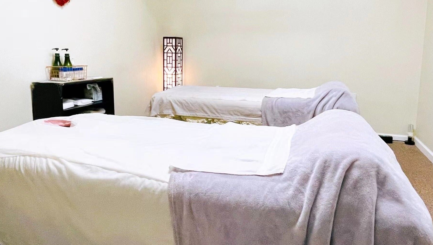 Tranquil massage room at Healing Spa, Midlothian, Virginia, US, featuring two cozy beds and soft lighting.