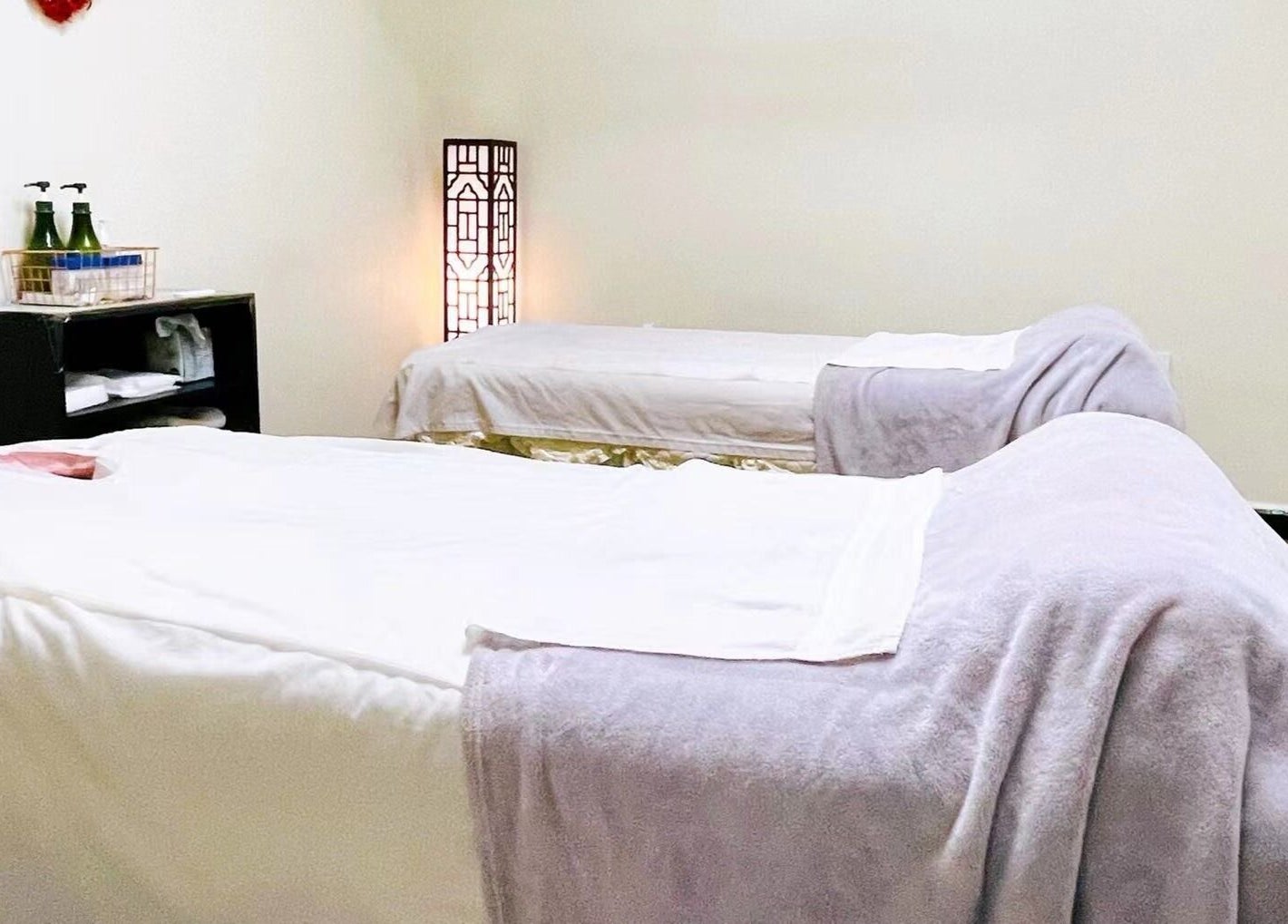 Tranquil massage room at Healing Spa, Midlothian, Virginia, US, featuring two cozy beds and soft lighting.