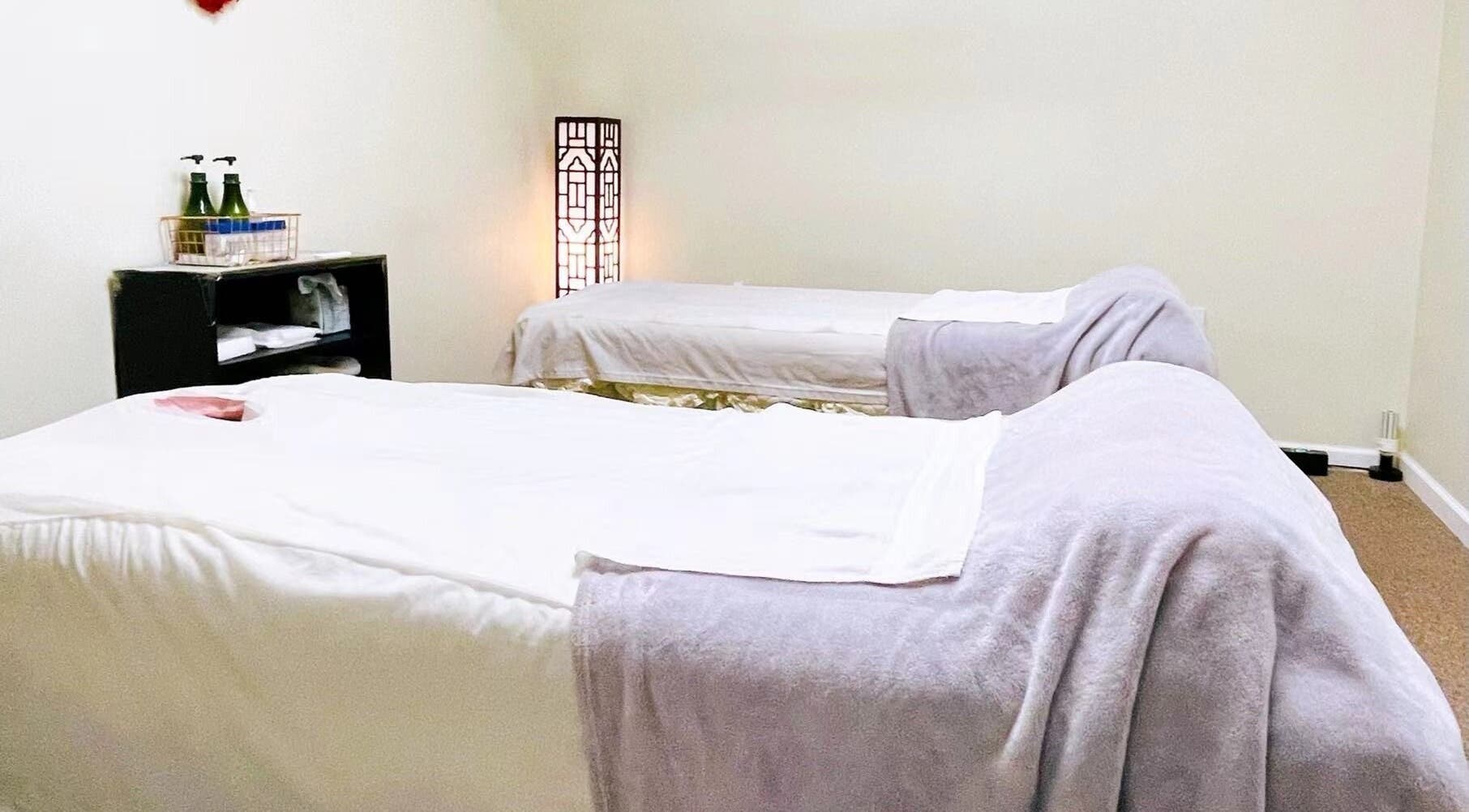 Tranquil massage room at Healing Spa, Midlothian, Virginia, US, featuring two cozy beds and soft lighting.
