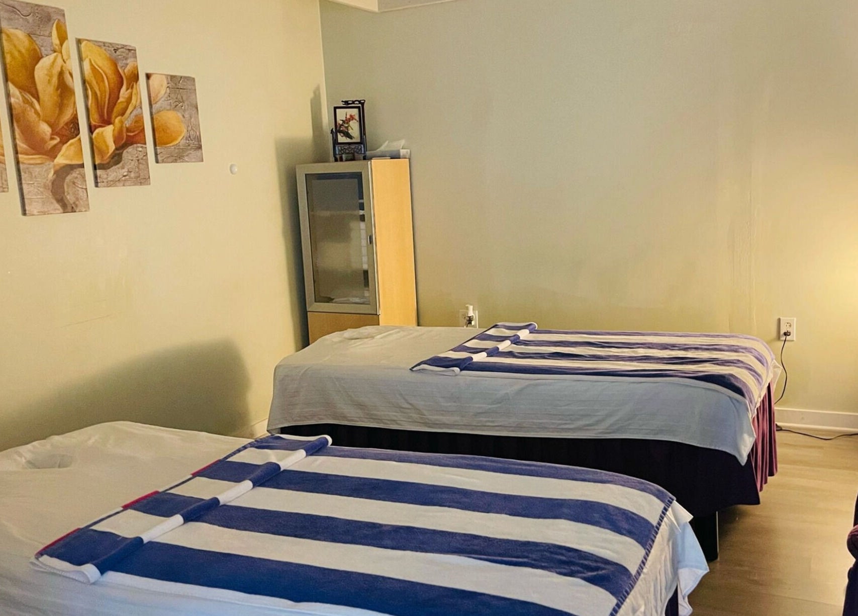 Healing Spa's serene massage room in Midlothian, Virginia, US featuring two beds and ambient lighting.