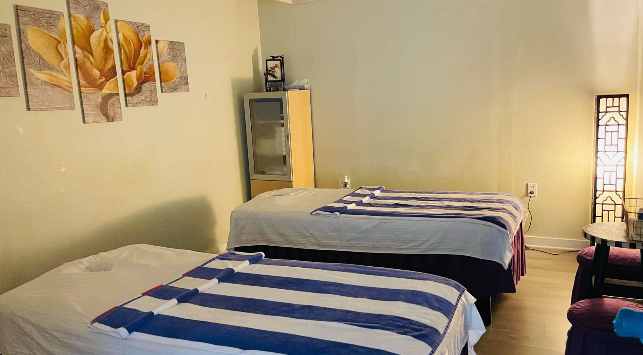 Healing Spa's serene massage room in Midlothian, Virginia, US featuring two beds and ambient lighting.