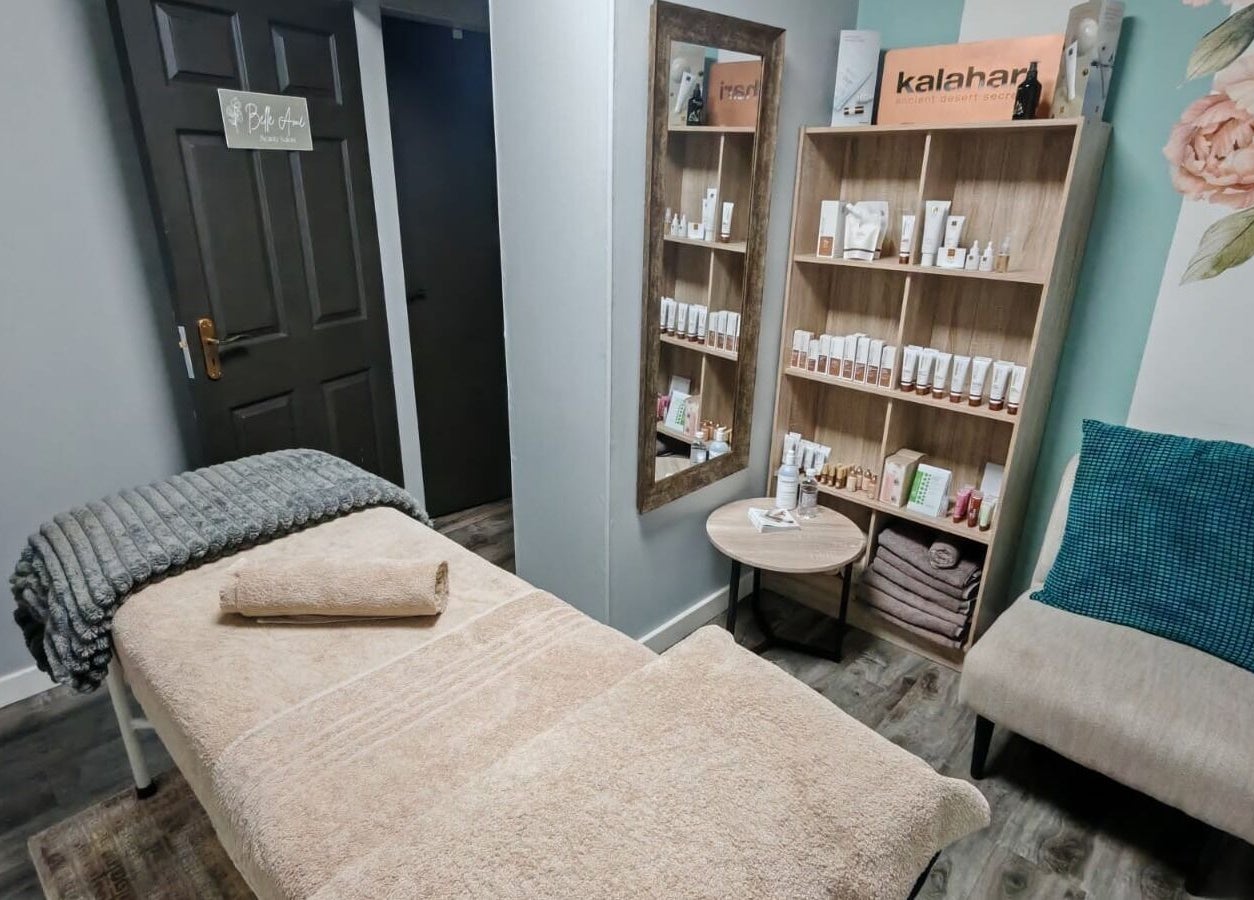 Relaxing treatment room at Belle Amé beauty salon, Centurion, Gauteng, ZA with massage table and product display.