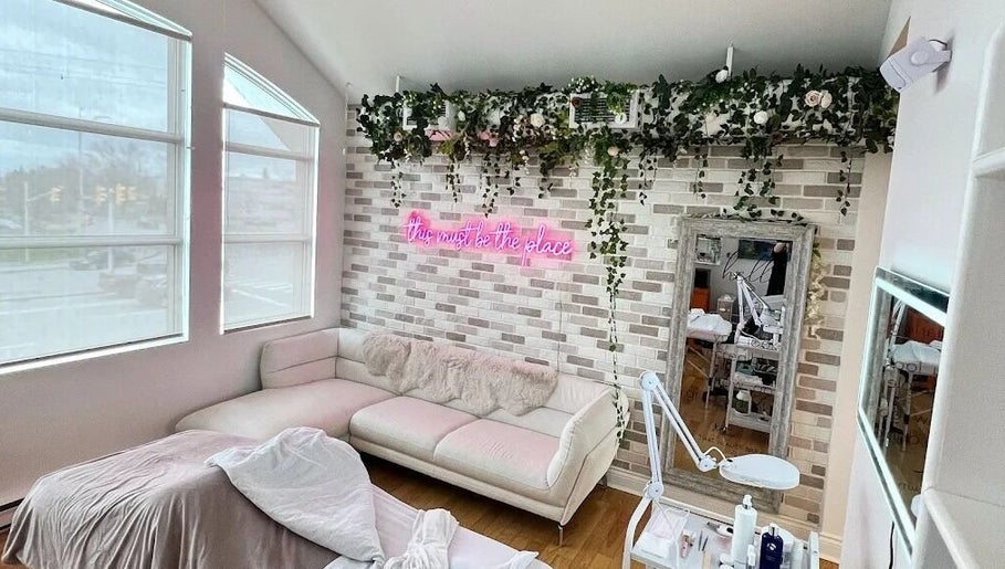 Chic interior of All That Beauty Bar in Ottawa, Ontario, CA featuring a comfortable sofa and chic decor.