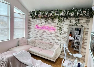 Chic interior of All That Beauty Bar in Ottawa, Ontario, CA featuring a comfortable sofa and chic decor.