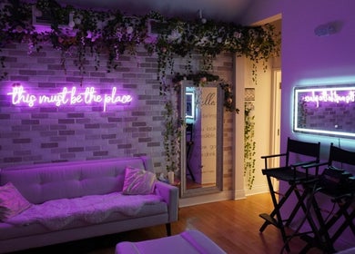 Relaxing lounge at All That Beauty Bar in Ottawa, Ontario, CA with neon lights and cozy seating.