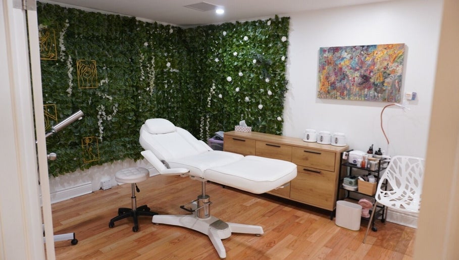Beauty treatment room with green wall at All That Beauty Bar, Ottawa, Ontario, CA, featuring a comfortable white chair.