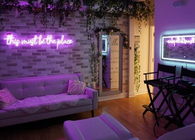 All That Beauty Bar in Ottawa, Ontario, CA features a serene lounge with vibrant neon sign and elegant decor.