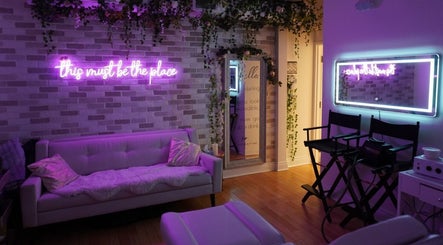 All That Beauty Bar in Ottawa, Ontario, CA features a serene lounge with vibrant neon sign and elegant decor.
