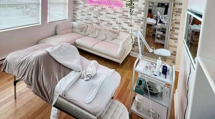 Relaxing treatment room at All That Beauty Bar, Ottawa, Ontario, CA with plush couch and treatment bed.