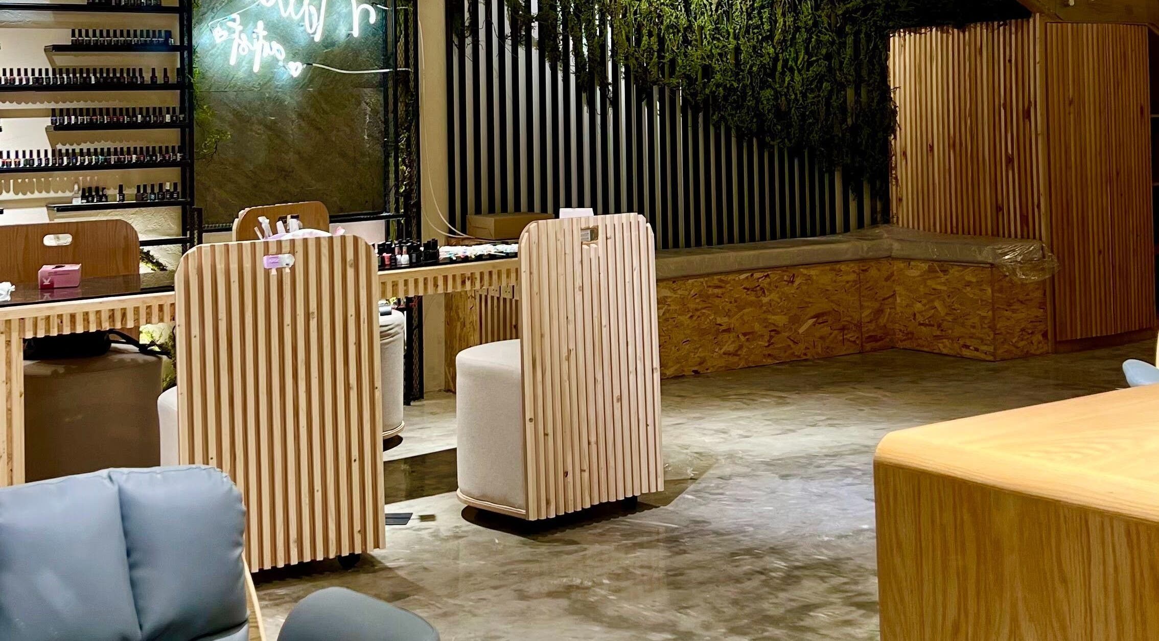 Elegant nail bar at Ombre Beauty Salon, Riyadh, featuring wooden counters and green décor for a serene ambiance.