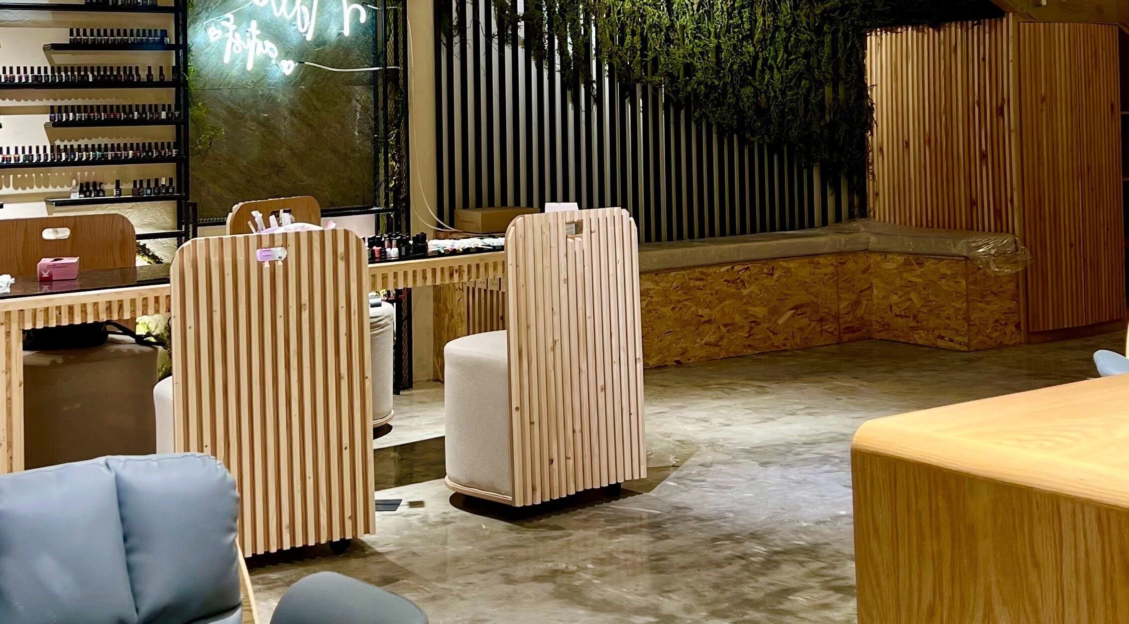 Elegant nail bar at Ombre Beauty Salon, Riyadh, featuring wooden counters and green décor for a serene ambiance.