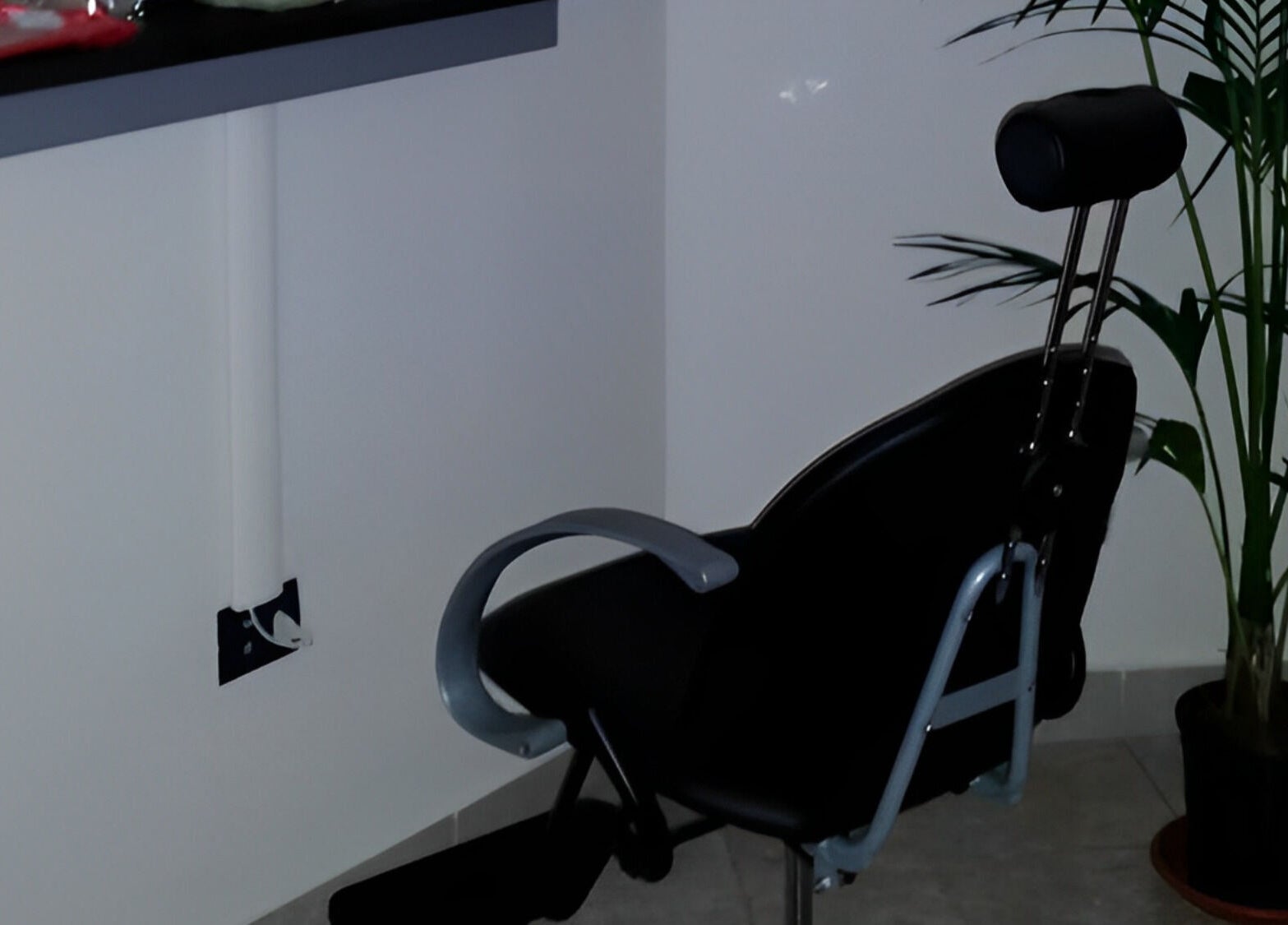 Sedia nera elegante presso Charme And Chic a Telese Terme, Campania, IT accanto a una pianta verde.