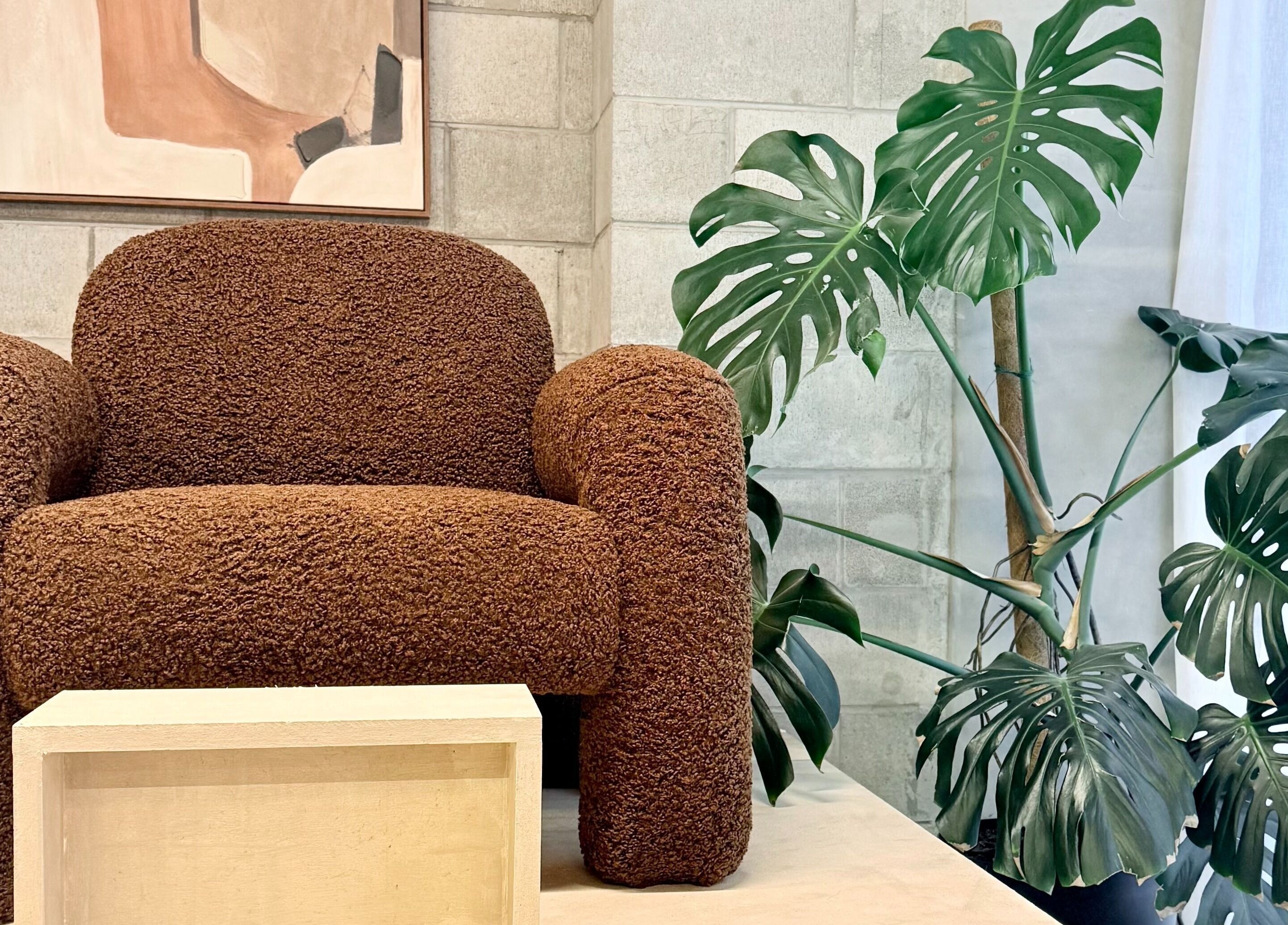 Comfortable armchair in Studio Ten, Auckland, Auckland, NZ, with lush plant decor and artwork.