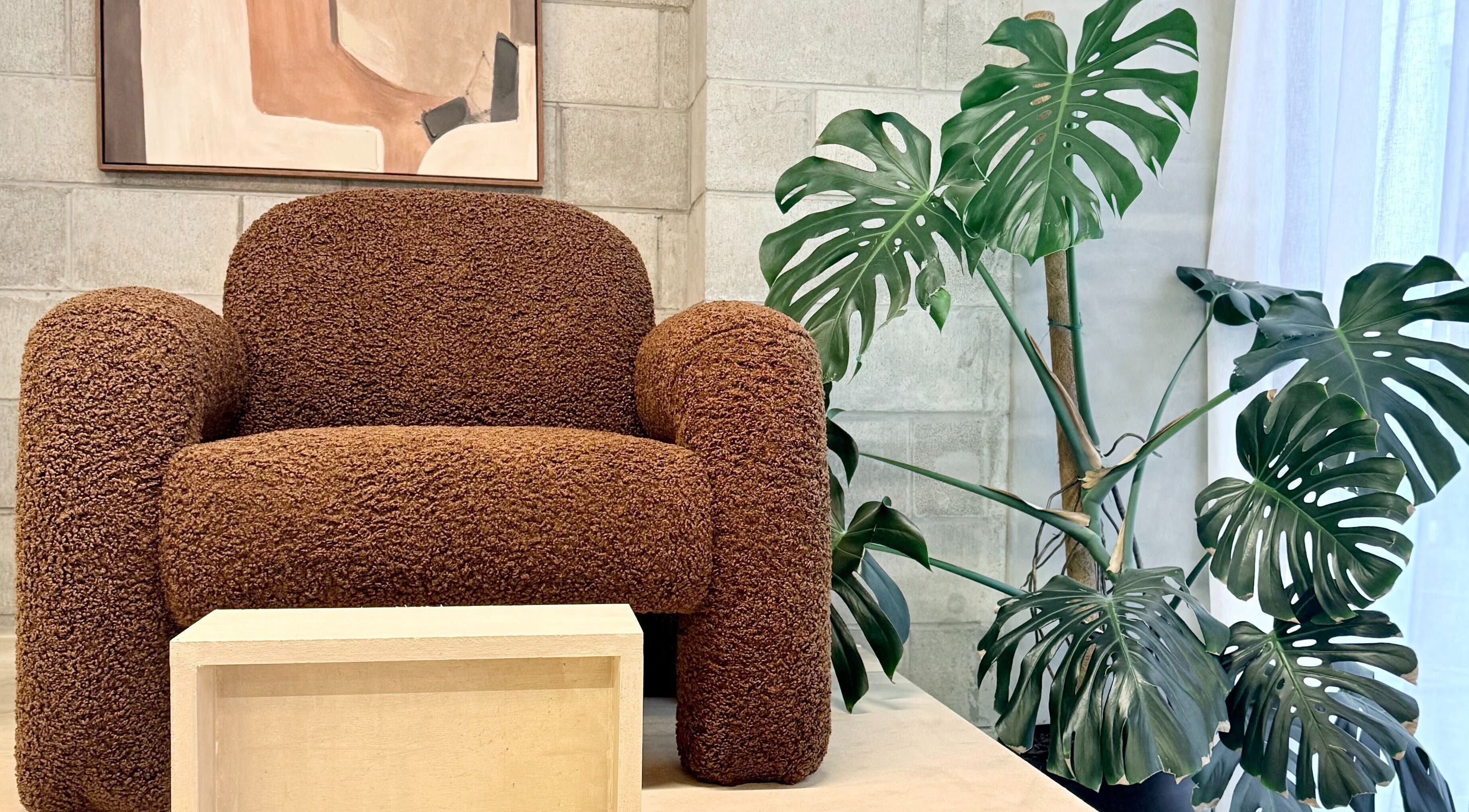 Comfortable armchair in Studio Ten, Auckland, Auckland, NZ, with lush plant decor and artwork.