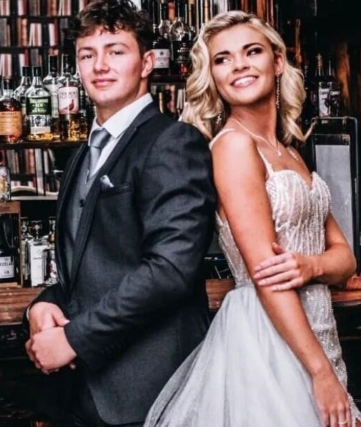Couple in formal attire at Go and Glow Studio, Centurion, Gauteng, ZA, with bar backdrop.