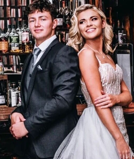 Couple in formal attire at Go and Glow Studio, Centurion, Gauteng, ZA, with bar backdrop.