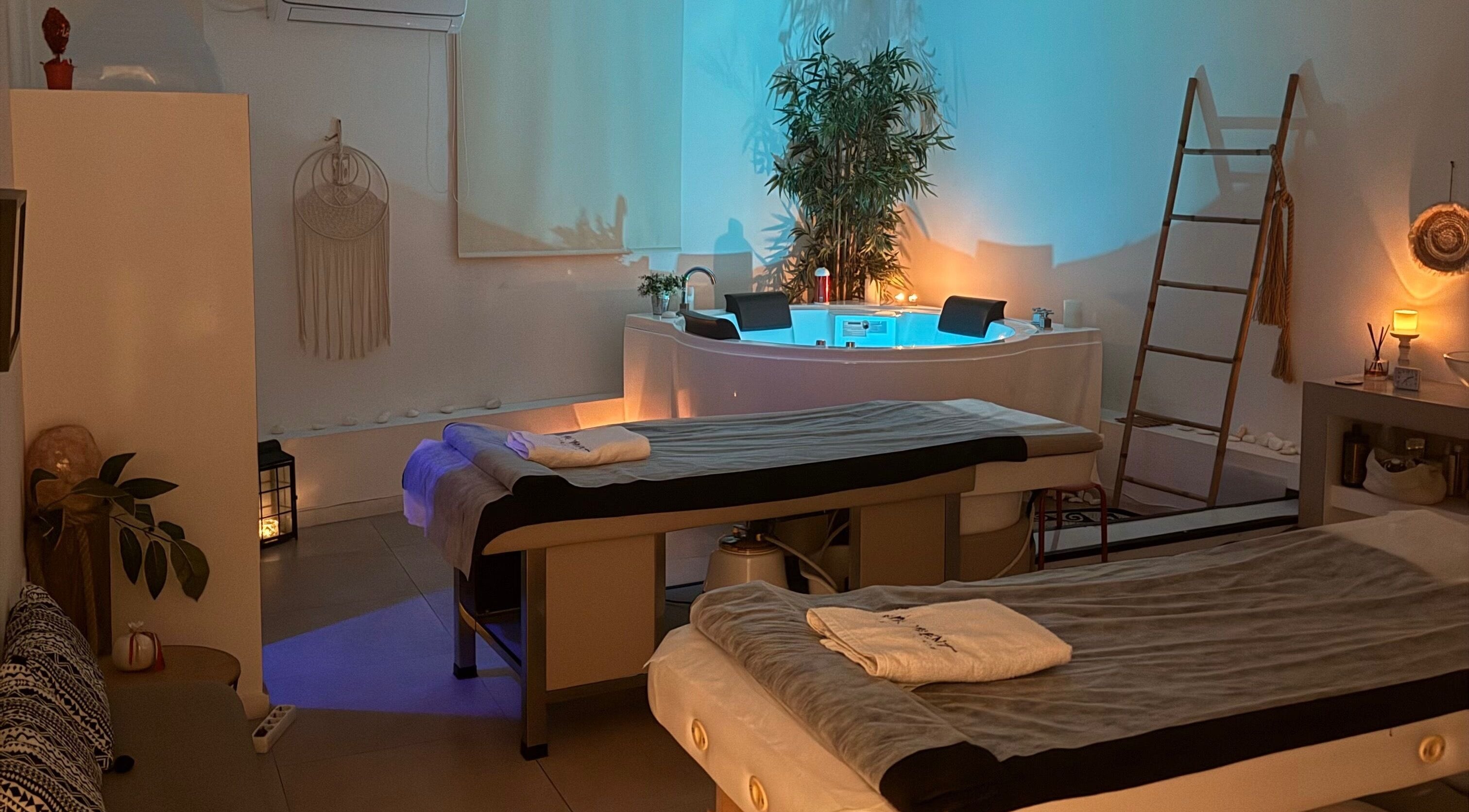 Cozy massage room at The Moment A Massage Boutique, Athina, GR, featuring warm lighting and relaxation areas.