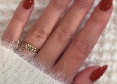 Elegant red nails with gold ring at Valentina Beauté, Montréal, Québec, CA, showcasing cozy style.