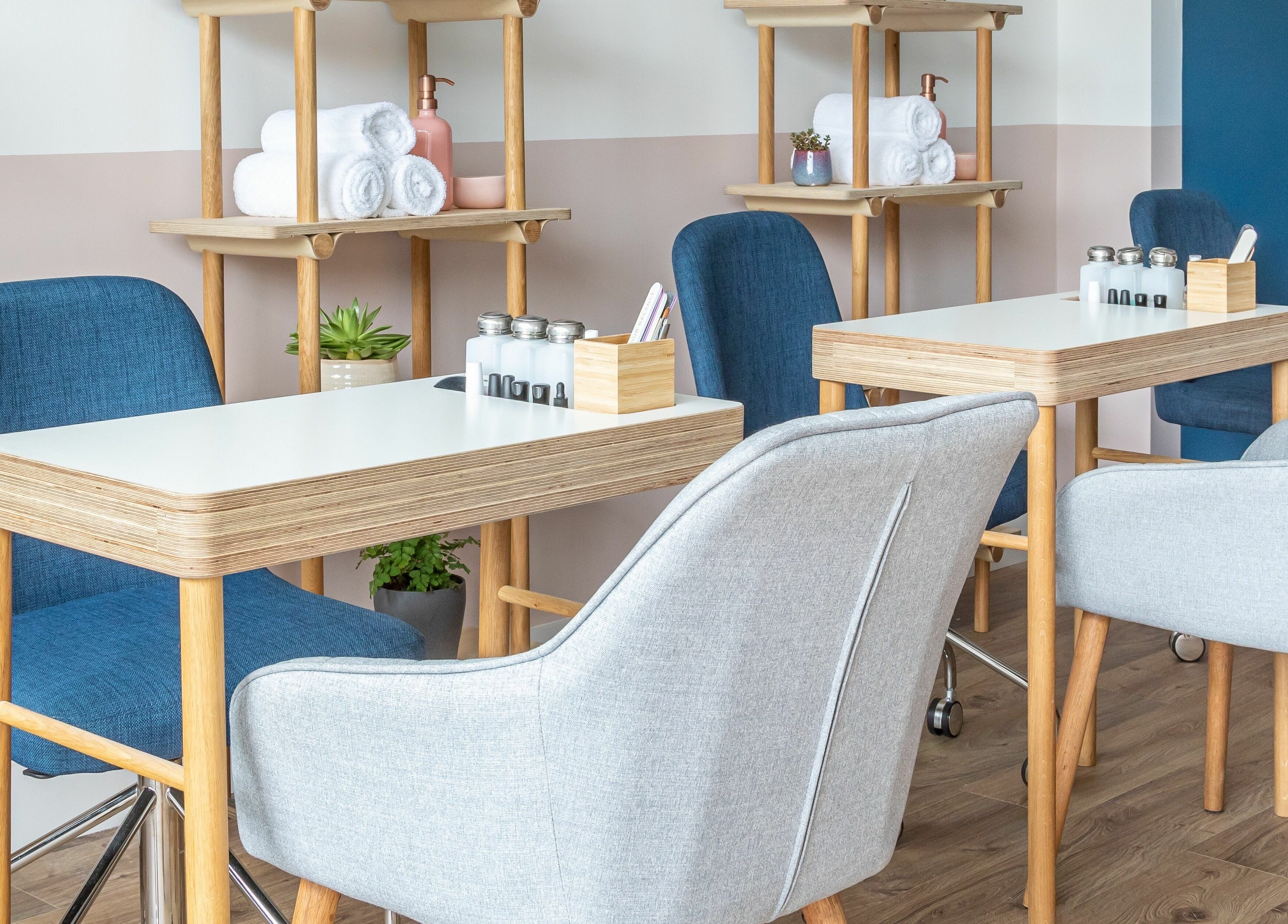 Calm, modern interior of Rose and River, London, England, GB with stylish nail salon tables and chairs.