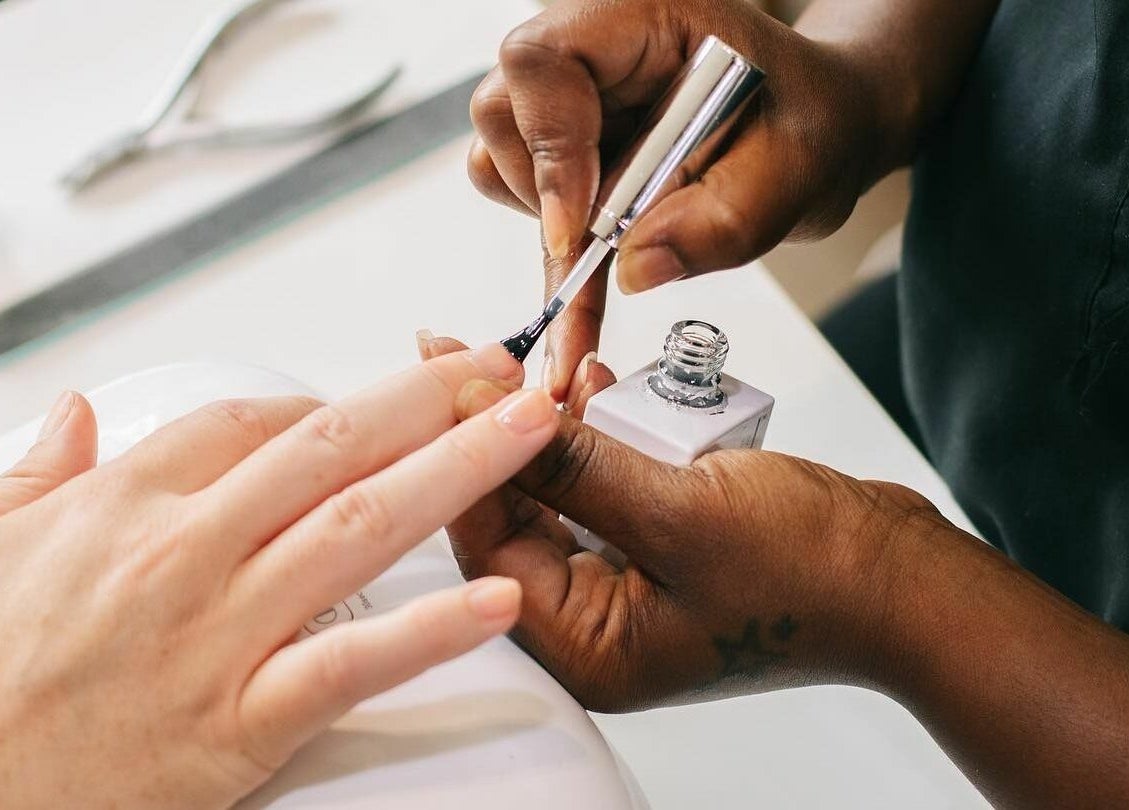 A manicure in progress at Rose and River, London, England, GB, showcasing skilled nail art application.
