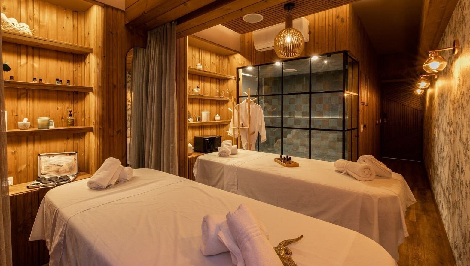 Elegant massage room at Celestino Spa, Medellín, Antioquia, CO, featuring wooden decor and cozy ambiance.